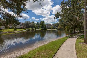 Sidewalk next to lake and trees